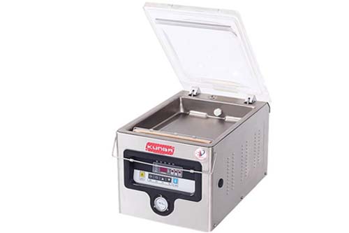 Open chamber of a tabletop vacuum packer showing removable drip tray and sealing bar