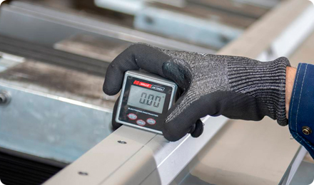 An operator is inspecting an industrial vacuum chamber sealer